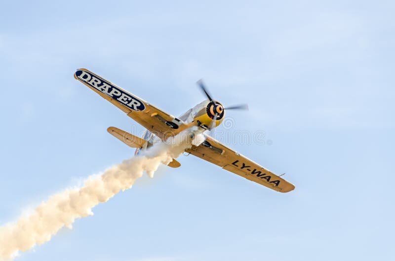 Aerobatic airplane pilot Jurgis Kairys training in the sky of the city. Colored airplane with trace smoke, airbandits, aeroshow