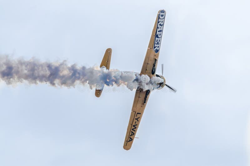 Aerobatic airplane pilot Jurgis Kairys training in the sky of the city. Colored airplane with trace smoke, airbandits, aeroshow