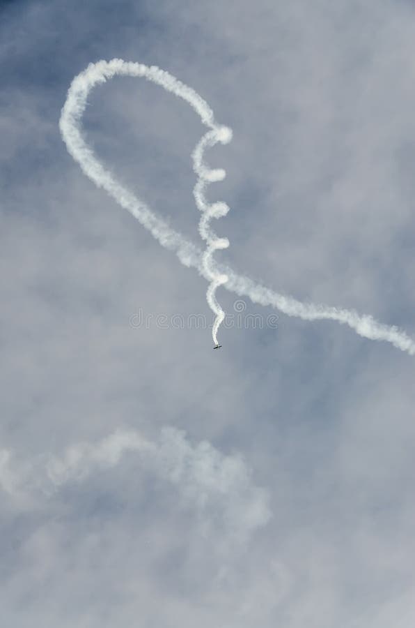 Aerobatic airplane pilot Jurgis Kairys training in the sky of the city. Colored airplane with trace smoke, airbandits, aeroshow