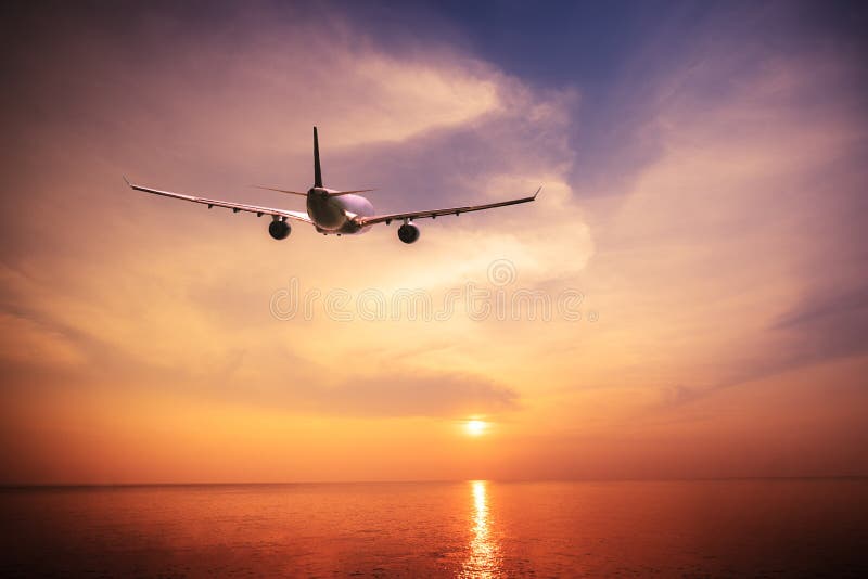 Aeroplano que vuela sobre el océano tropical asombroso en la puesta del sol Viaje de Tailandia