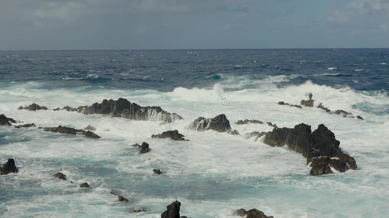 Aersiell syn på vågor som skjuter i hav och berg i vatten