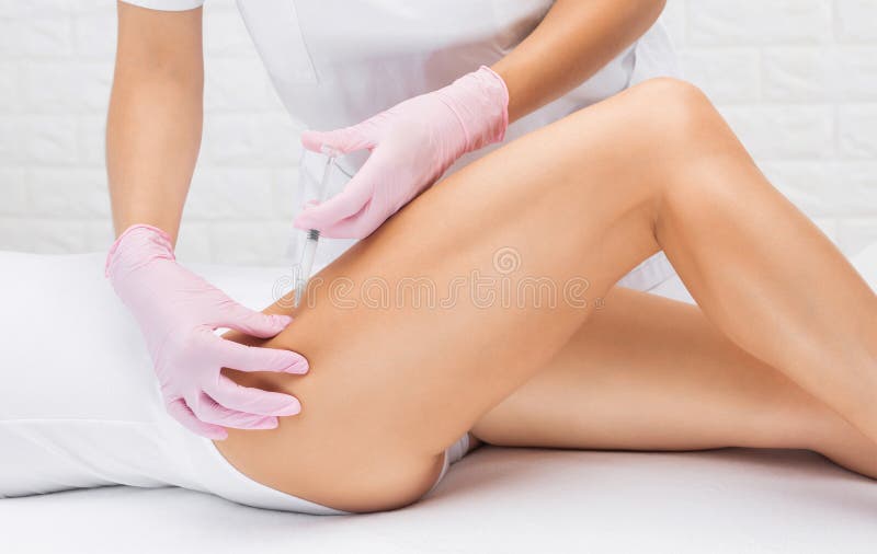 Aesthetic cosmetologist makes lipolytic injections to burn fat on the thighs and body of a woman. Female aesthetic cosmetology in