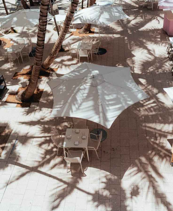 Aesthetic Outdoors Cafe with a White Umbrella and White, Small Tables