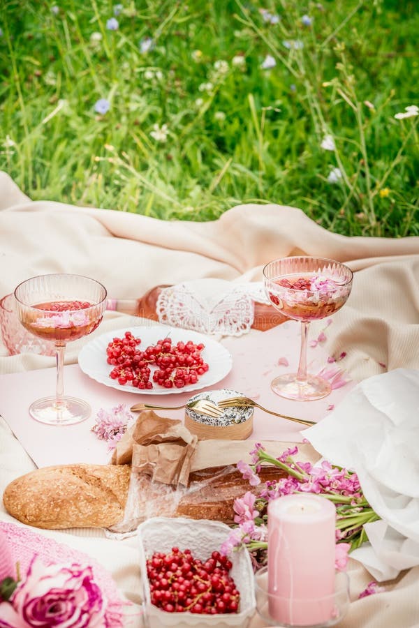 Aesthetic picnic outdoors with wine glasses bread berries and flowers.  Rustic picnic with neutral tones colours. Stock Photo by  ©lamapacas.gmail.com 378420028