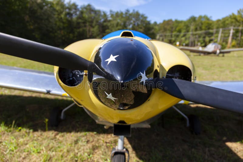 Afbeelding van het voorpaneel van een glanzend gele twee vaste vleugelvliegtuigen