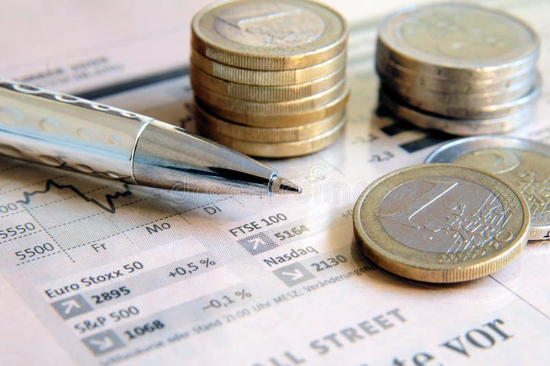 Euro money coins and silver colored ball pen on a light pink colored stock market report. Euro money coins and silver colored ball pen on a light pink colored stock market report