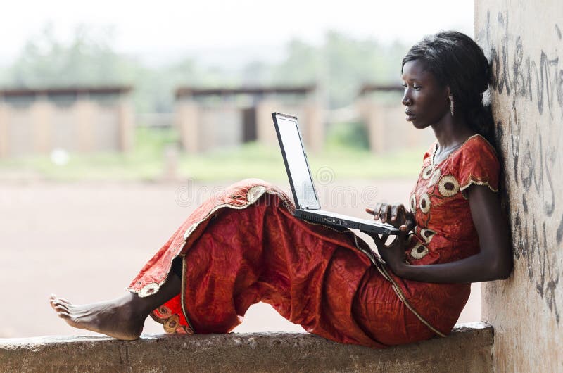 Barefoot African Model Working On Her Laptop Computer Business Symbol. Education for Africa: Technology Symbol African Woman Studying Learning Lesson. Barefoot African Model Working On Her Laptop Computer Business Symbol. Education for Africa: Technology Symbol African Woman Studying Learning Lesson