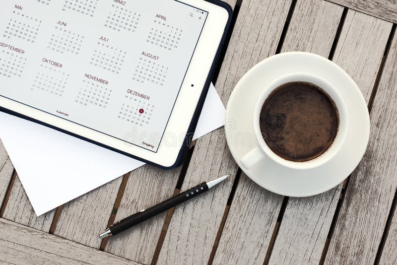 Affare, calendari, appuntamento Tavola dell'ufficio con il blocco note, computer, tazza di caffè