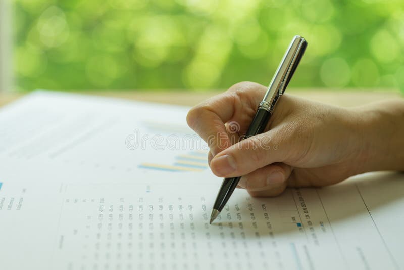 Affare, investimento o rassegna di rapporto finanziaria, penna di tenuta della mano che esamina rapporto di finanza con la stampa fotografie stock Affare, investimento o rassegna di rapporto finanziaria, penna di tenuta della mano che esamina rapporto di finanza con la stampa fotografie stock