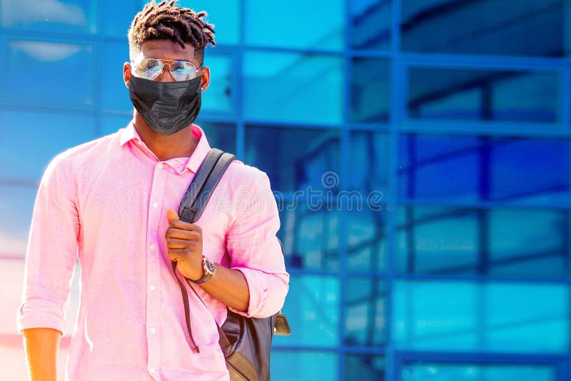 Affascinante docente universitario africano alla moda, maschio americano, con occhiali in abiti eleganti, camicia nera con zaino i fotografie stock