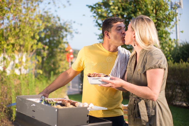 Affectionate Husband and Wife Making BBQ in Backyard Stock Ph pic