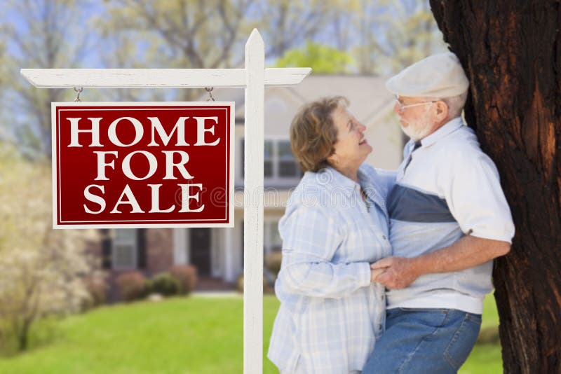 Happy Senior Couple Front of For Sale Real Estate Sign and House. Happy Senior Couple Front of For Sale Real Estate Sign and House.