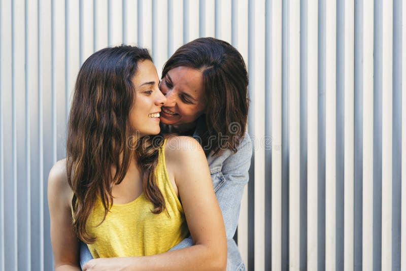 Affectionate Woman Kissing Her Happy Girlfriend Smiling, Same Sex Relationship Concept Stock Photo image
