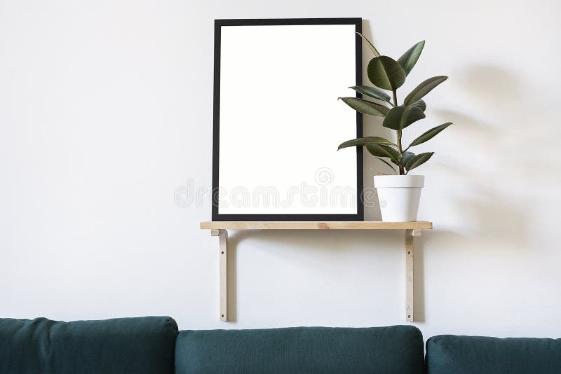 Poster in black frame in white stylish modern interior on a wall above green sofa. Design template mockup. Poster in black frame in white stylish modern interior on a wall above green sofa. Design template mockup.