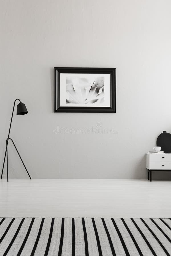 Affiche sur le mur gris dans l'intérieur de salon avec le tapis rayé photos libres de droits Affiche sur le mur gris dans l'intérieur de salon avec le tapis rayé photos libres de droits