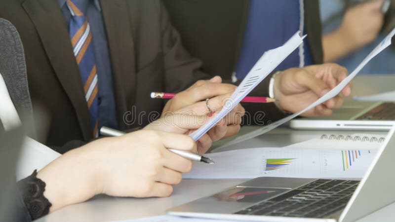 Affärsfolket använder bärbara datorn och arbetar på pappers- presentationsgraf arkivfoto Affärsfolket använder bärbara datorn och arbetar på pappers- presentationsgraf arkivfoto