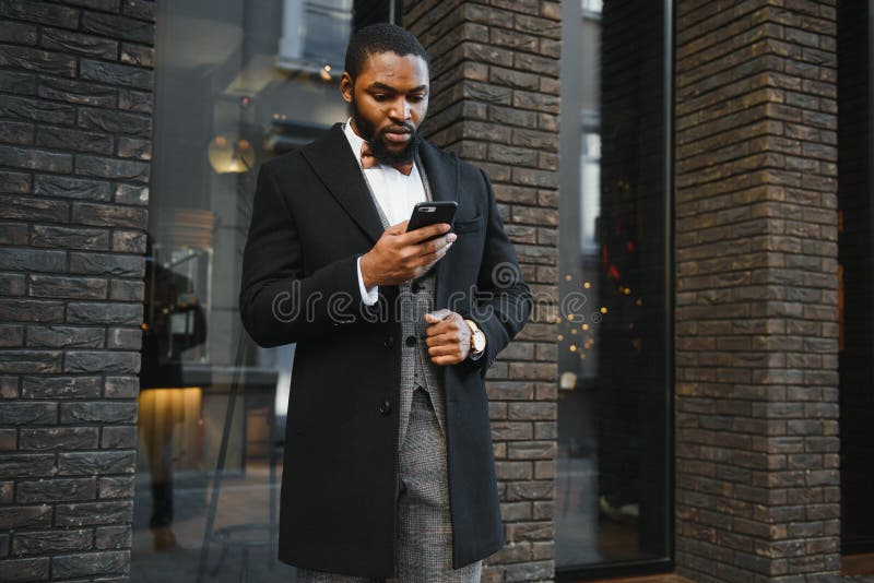 Affärskommunikation. lycklig ung afrikan-man på formella kläder som pratar på mobiltelefon och leende medan han står utomhus arkivbilder