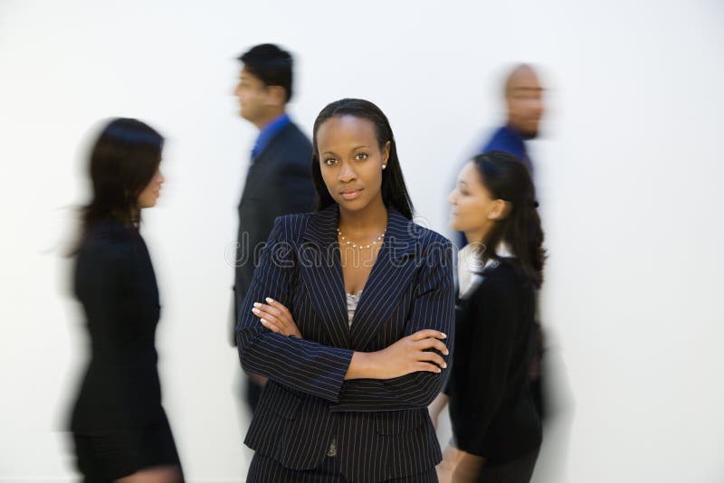 Porträtt av en affärskvinna med andra som går förbi fotografering för bildbyråer