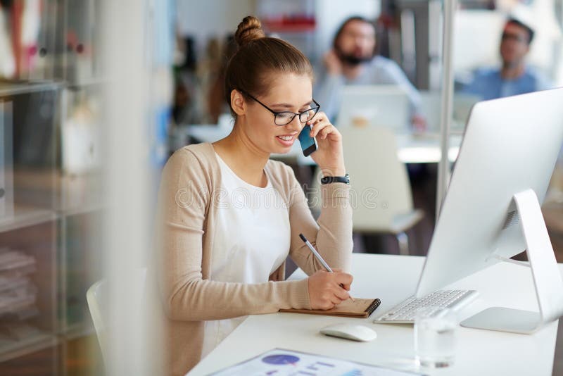 Affärskvinna på telefonen med partners arkivfoto Affärskvinna på telefonen med partners arkivfoto