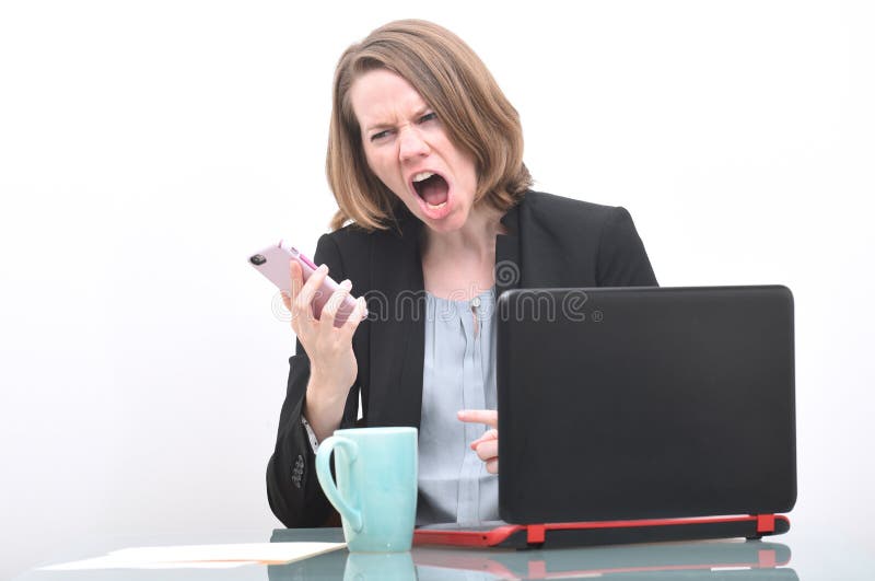 Business woman screaming into phone while at desk. Business woman screaming into phone while at desk