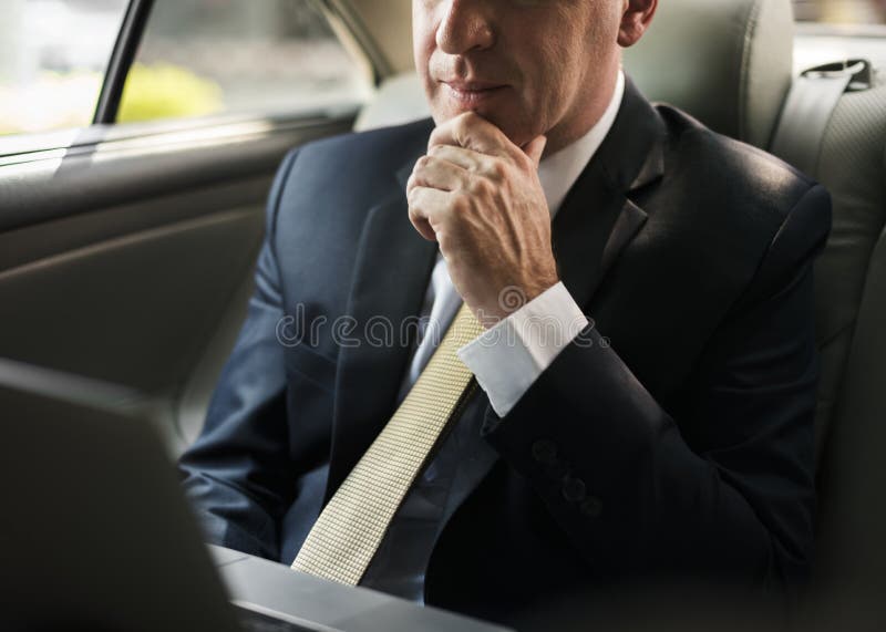 Affärsman inom en bil som arbetar på hans bärbar dator royaltyfria bilder Affärsman inom en bil som arbetar på hans bärbar dator royaltyfria bilder