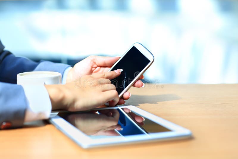 Affärsman som använder den digitala minnestavladatoren med den moderna mobiltelefonen royaltyfria foton Affärsman som använder den digitala minnestavladatoren med den moderna mobiltelefonen royaltyfria foton