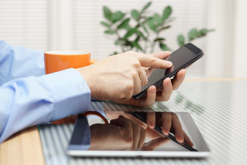 Affärsman som använder mobiltelefonen och den digitala minnestavlan royaltyfri bild
