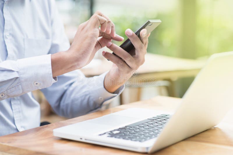 Affärsman som använder smartphone- och bärbar datordatoren arkivfoton