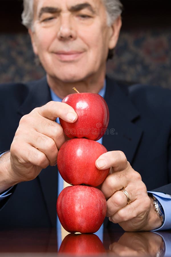 Affärsman som balanserar äpplen fotografering för bildbyråer