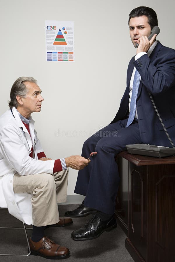 Affärsman som har en läkarundersökning arkivfoton
