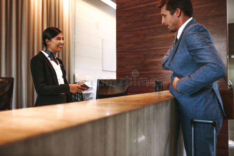 Affärsman som in kontrollerar på hotellmottagandet royaltyfri fotografi Affärsman som in kontrollerar på hotellmottagandet royaltyfri fotografi