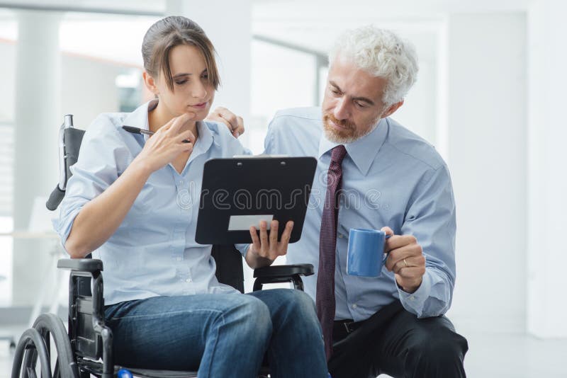 Businessman showing a document on a clipboard to a young women in wheelchair, assistance and help concept. Businessman showing a document on a clipboard to a young women in wheelchair, assistance and help concept