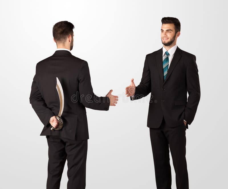 Two opposing businessman shake hands, one of them hiding a weapon behind his back. Two opposing businessman shake hands, one of them hiding a weapon behind his back