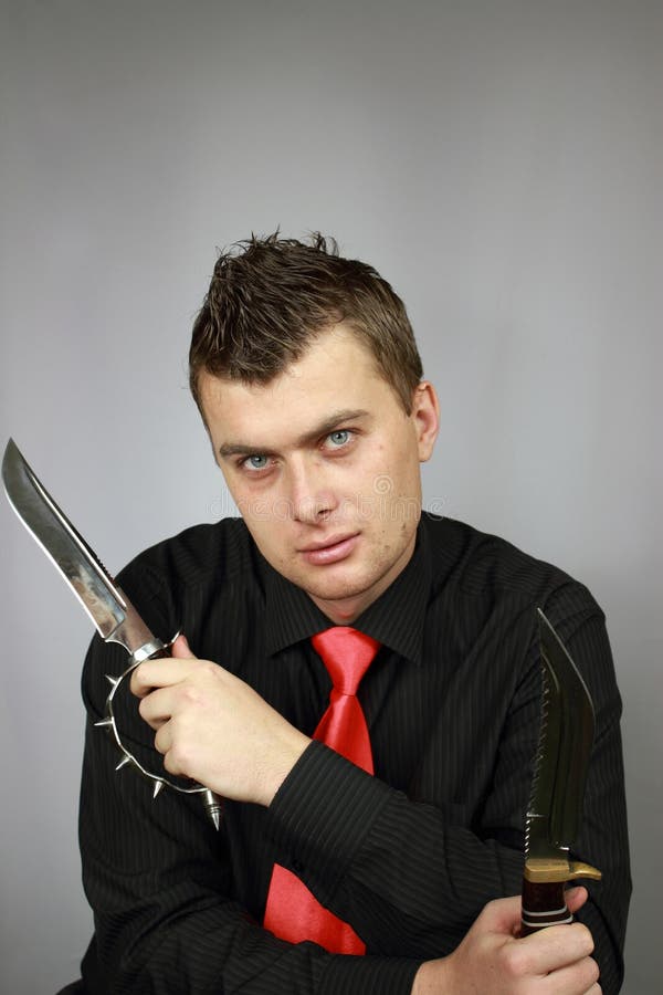 Businessman in a black shirt with a knife in hands. Businessman in a black shirt with a knife in hands