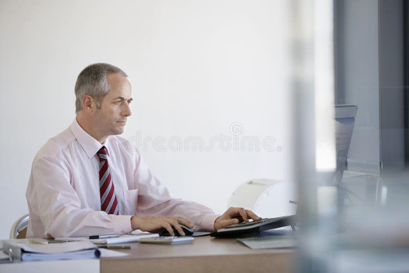 AffärsmanUsing Computer At skrivbord royaltyfri fotografi