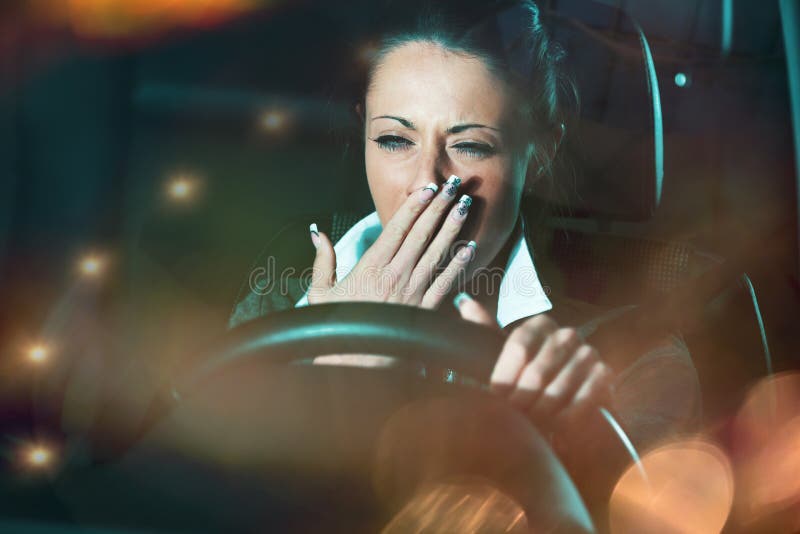 Distracted exhausted tired woman driving a car late at night. Distracted exhausted tired woman driving a car late at night