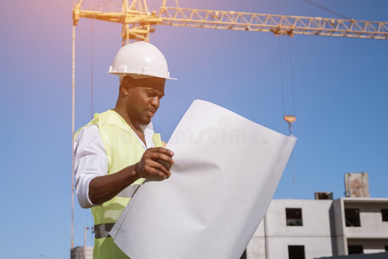 African American Architect Compares Building To Drawings Stock Photo