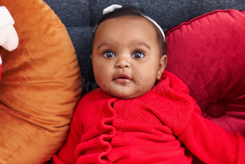 African American Baby Sitting on Sofa with Relaxed Expression at Home