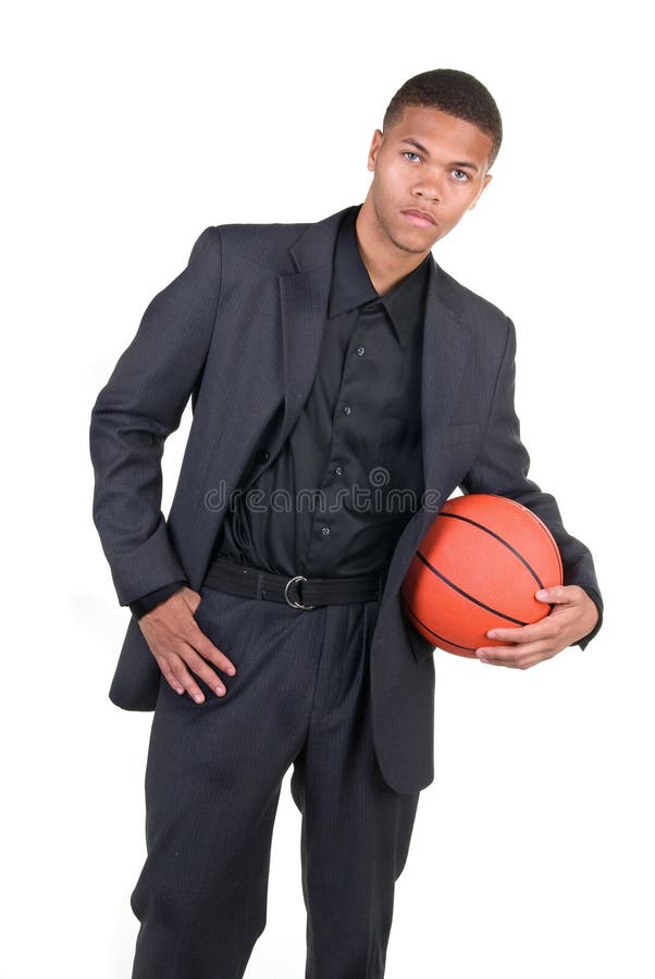 An African American basketball player poses in his business dress.
