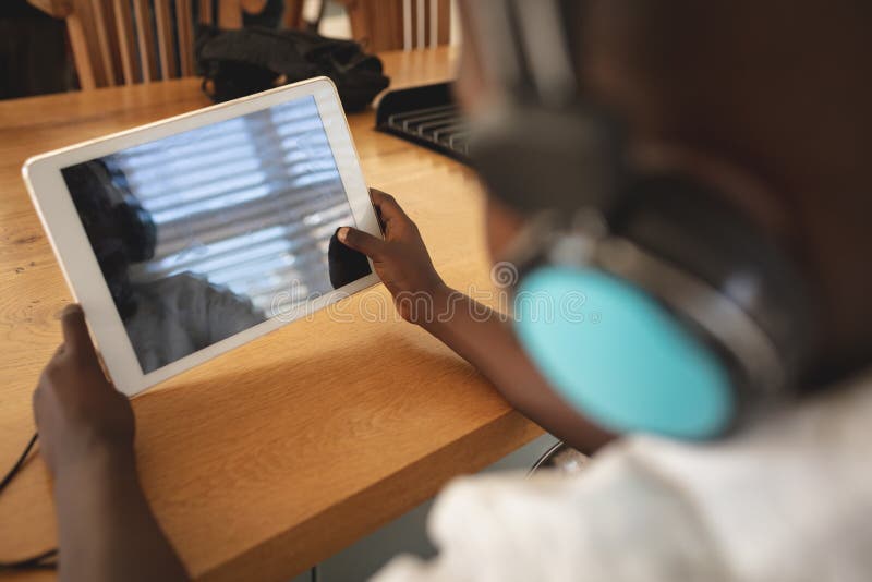 African American boy using digital tablet at dining table in kitchen royalty free stock image African American boy using digital tablet at dining table in kitchen royalty free stock image