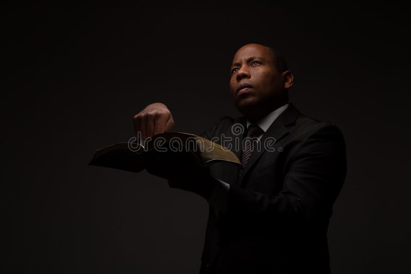 African American Christian Man with The Holy Scriptures, The Word of God, Pointing to the Bible