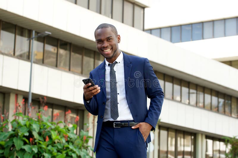 African american corporate businessman laughing with mobile phone in the city