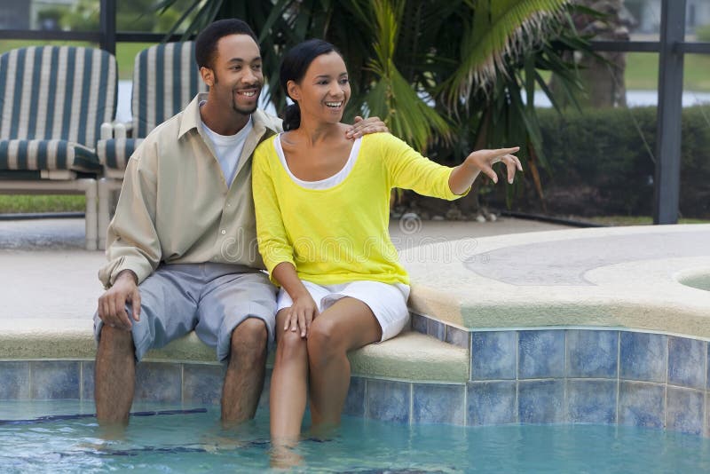 African American Couple Sitting By Swimming Pool royalty free stock photo African American Couple Sitting By Swimming Pool royalty free stock photo