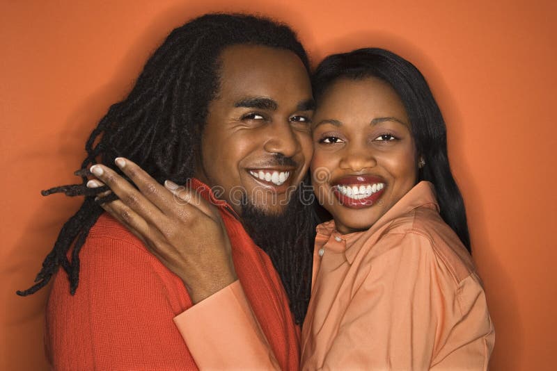African-American couple wearing orange clothing on orange backgr stock images African-American couple wearing orange clothing on orange backgr stock images