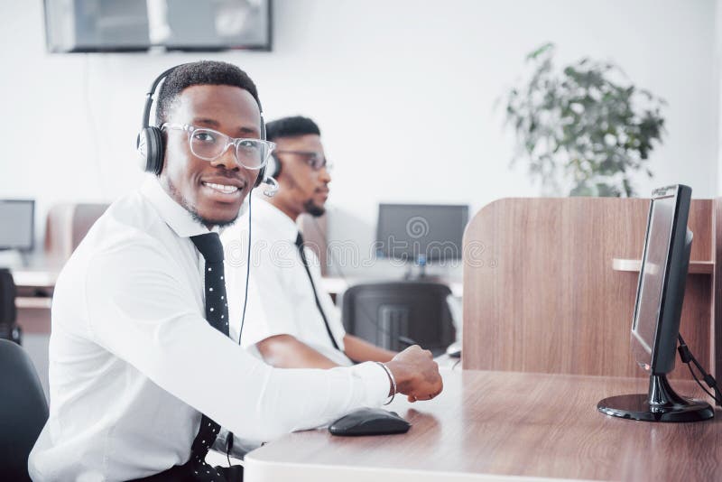 African american customer support operator with hands-free headset working in the office