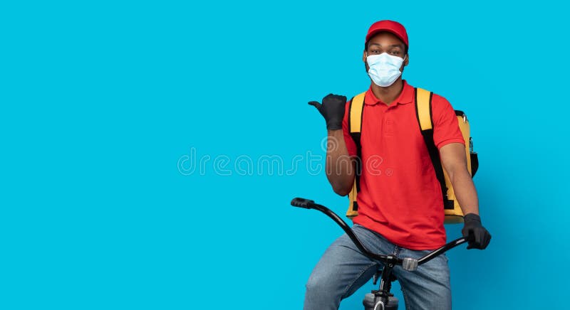 Delivery man with gloves looking away while sitting on bicycle