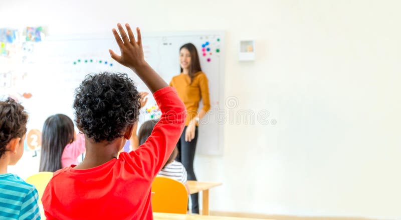 Americano etnia un bambino mano su la risposta domanda da l'insegnante la classe, ASILO asilo formazione scolastica, deridere su formato pubblicitario destinato principalmente all'uso sui siti web spazio aggiunta il tuo.