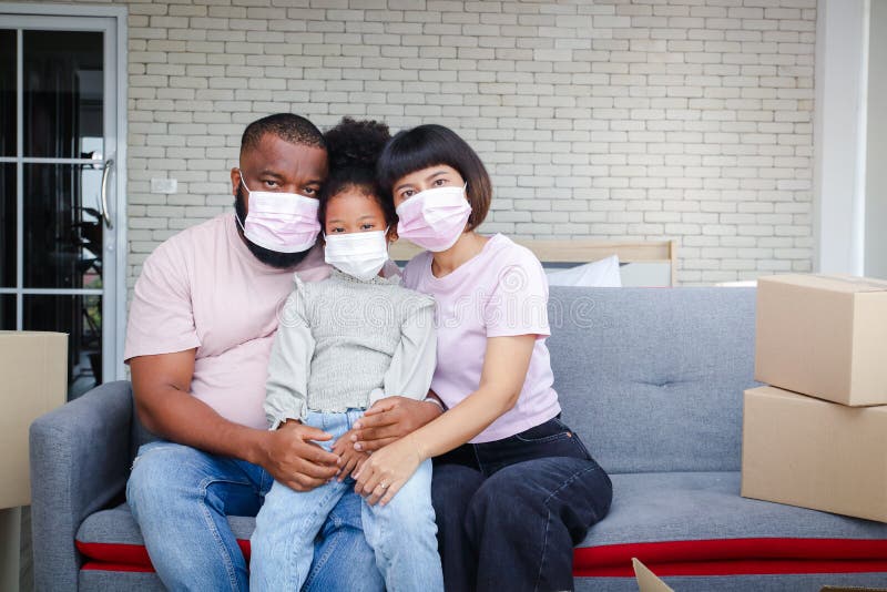 African American family moves into a new home, sitting on the sofa in the living room.