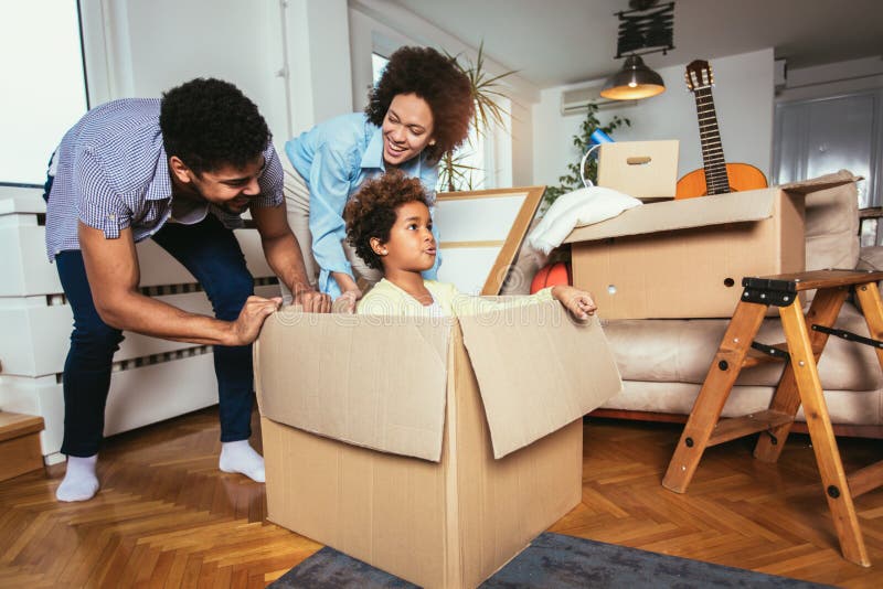 African American family, parents and daughter, unpacking boxes and moving into a new home