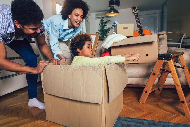 African American family, parents and daughter, unpacking boxes and moving into a new home